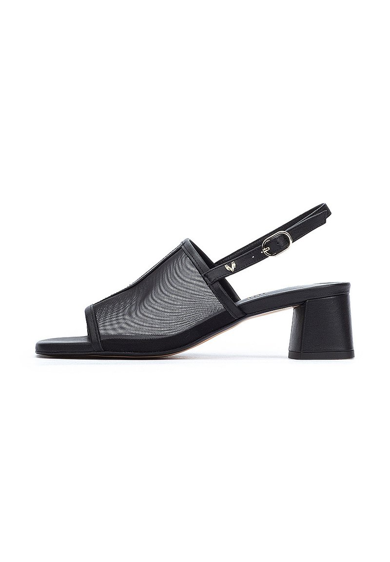 Zapatos de tacón negro tipo slingback con parte superior de malla, punta cuadrada y tacón grueso. Incluye una correa con hebilla para ajuste. Superficie lisa.