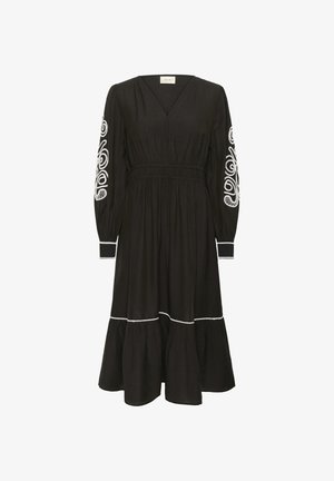 Rochie neagră cu mâneci lungi, decolteu în V și talie strânsă. Prezintă modele brodate albe pe mâneci și pe margine. Fuste evazate.