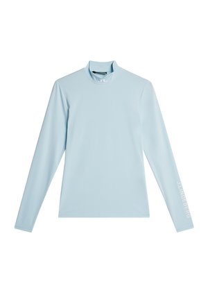 Long-sleeve shirt in light blue, made of smooth fabric with a high neckline. Features a logo in white on the left sleeve.