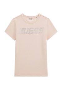 Vaaleanpunainen puuvillapaita, jossa on lyhyet hihat ja joka on varustettu kimaltelevalla "GUESS" -logolla hopeanvärisistä strasseista rinnassa. Pyöreä kaula-aukko.