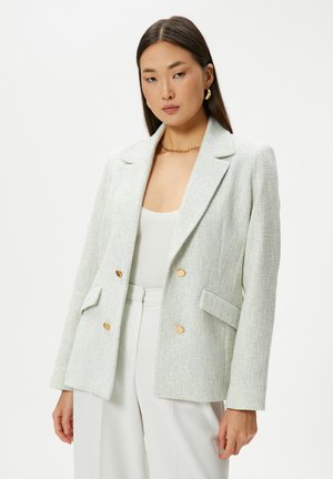 Double-breasted blazer in a textured light blue and white fabric, featuring gold buttons, two front pockets, and a notched lapel design.