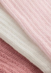 Tessuto a maglia testurizzato in tre colori: rosa chiaro, bianco e rosa tenue, disposto in strati con un sottile motivo orizzontale.