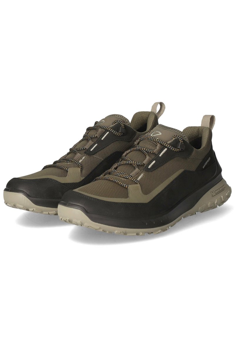 Chaussures de randonnée en maille légère et matériau en caoutchouc. Schéma de couleurs vert olive foncé et noir, semelle à grip texturé et lacets élastiques.