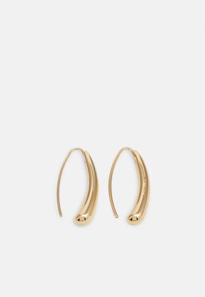 Paire de boucles d'oreilles créoles incurvées ton or avec des formes ovales allongées et des crochets fins en fil métallique.