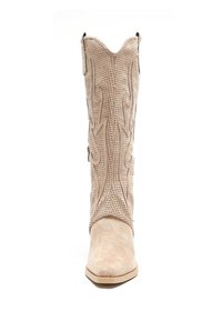 Bota de cowboy beige con cuero perforado, parte superior curvada con costuras decorativas, punta afilada y tacón bajo.