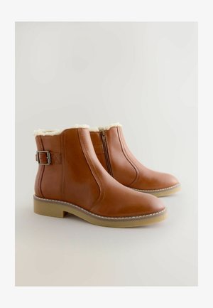 Braune Leder-Stiefeletten mit einem Futter aus Kunstfell, seitlichem Reißverschluss und einem dekorativen Riemen mit Schnalle; flache Gummisohle.