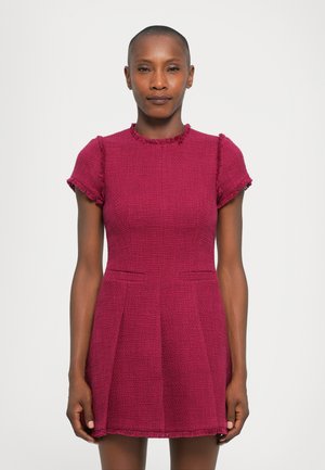 Fuksia neulemekko lyhyillä hihoilla, teksturoitu kangas, pyöreä pääntie, risaiset reunat ja sivutaskut. A-linjainen siluetti.