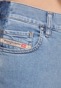 Světle modré džíny z denimu s přední kapsou a štítkem s nápisem "Diesel Industry Denim Division", prošité detaily a regular fit.