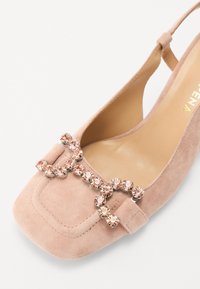 Roza roza nubuk slingback čevlji s kvadratnim nosom, ki imajo dekorativen aranžma roza kristalov na zgornjem delu.