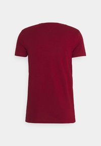 Maroon short-sleeve t-shirt, cotton fabric, crew neck, relaxed fit, plain design with no visible logos or patterns, subtle texture.