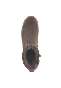 Bruine suède enkellaars met een zachte fake fur voering, ronde neus en een gestructureerde rubberen buitenzool. Sluitingsdetail aan de zijkant nabij de opening.