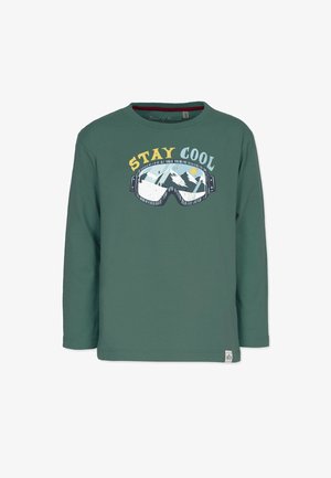 Grøn langærmet skjorte med skibrille-grafik, der viser sneklædte bjerge og sol, med teksten "STAY COOL" over brillen.