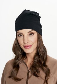 Czarna czapka beanie z luźnym fasonem i teksturowaną powierzchnią, z zagiętymi sekcjami na górze i dopasowanym dołem.