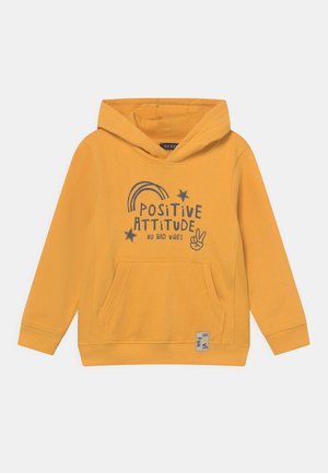 Sweat à capuche jaune moutarde avec poche avant, imprimé avec "Positive Attitude No Bad Vibes", étoiles, arc-en-ciel et un graphique de main faisant le signe de la paix.