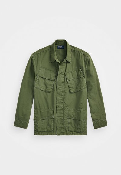Casaco militar de cor verde-oliva com mangas longas, colarinho pontudo e quatro bolsos frontais. Confeccionado em um tecido leve e texturizado.