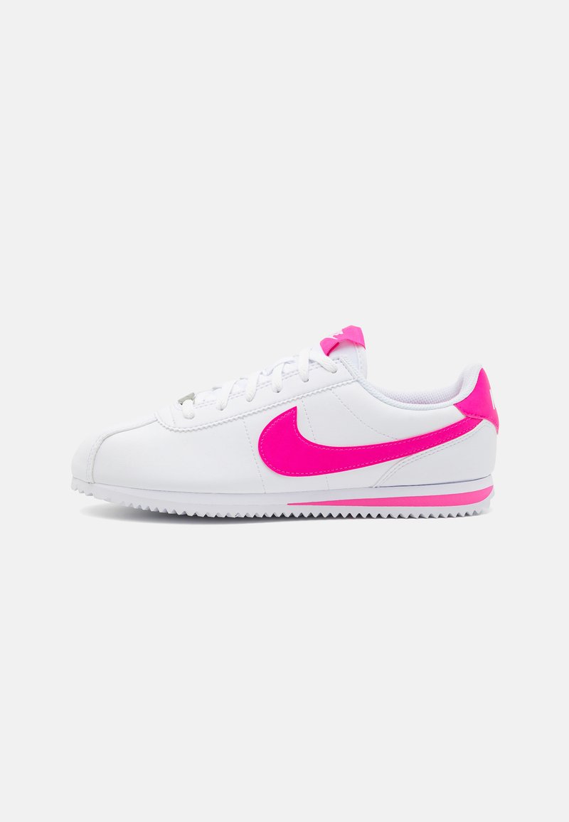 Sapatilhas brancas com uma swoosh rosa da Nike, parte superior em couro texturizado, atacadores brancos e pormenores rosa no calcanhar e na sola. Design retro clássico.