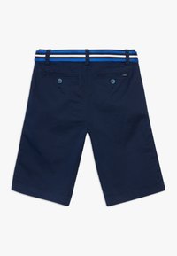 Námořnické modré šortky vyrobené z bavlny s hladkým povrchem, s pruhovaným modro-bílým pasem a dvěma zadními kapsami na knoflíky.