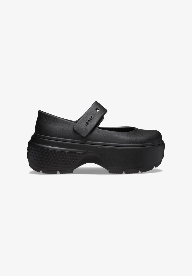 Chaussure noire de style Mary Jane avec un bout arrondi, une sangle ajustable, une semelle en plateforme texturée et une finition mate lisse.
