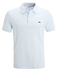 Light blue polo shirt made of textured fabric, featuring a collar, two buttons, and a small green Lacoste logo on the left chest.