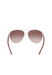 Ochelari de soare aviator cu ramă din metal argintiu, lentile maro cu tonuri degradate și brațe din plastic roșu. Dispune de tampoane nazale ajustabile și un design cu dublă punte.