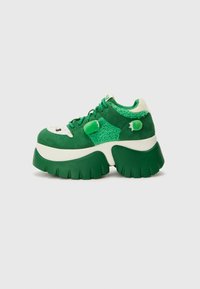 Sneaker platform verdi con suede e tessuto testurizzato, punta rotonda, suola prominente, lacci e accenti giocosi sulla parte superiore.