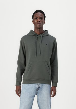 Dark green hoodie made of soft fabric, featuring a kangaroo pocket, adjustable drawstring hood, and a small logo on the chest.