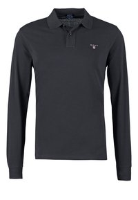 Pitkähihainen poolopaita tummanharmaasta kankaasta, jossa on klassinen kaulus, kaksinappinen kaulus ja pieni brodeerattu logo rinnassa.