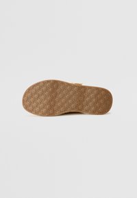Shoe sole view featuring a textured brown rubber design with a geometric pattern, smooth edges, and a clean finish.
