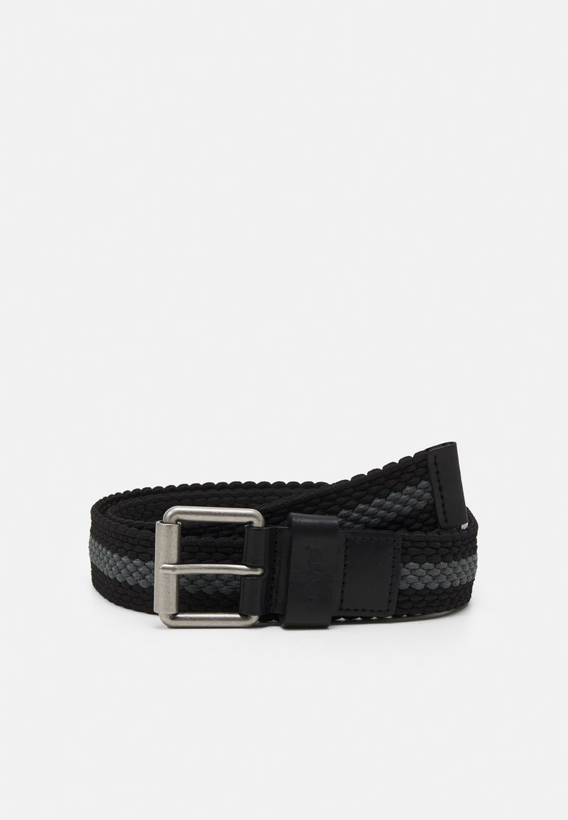 Ceinture en tissu noir tissé avec une bande grise, boucle rectangulaire en métal argenté et accents en cuir noir, enroulée sur un fond blanc.