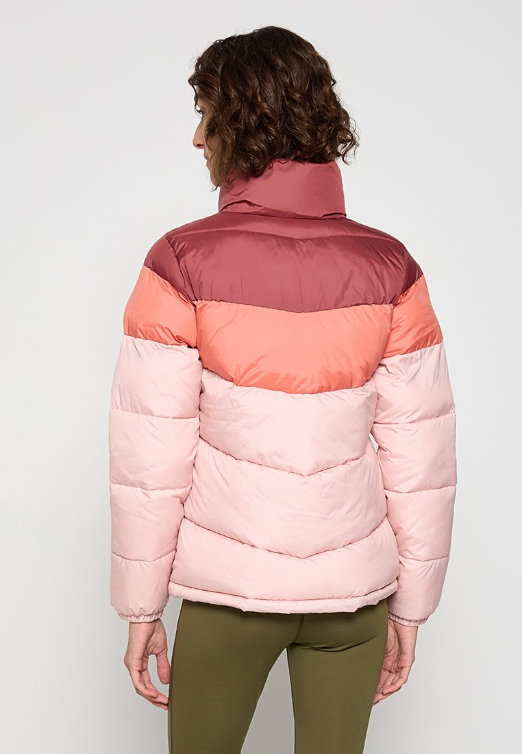 Lekka kurtka puchowa w kolorach różowym, koralowym i bordowym. Posiada wysoki kołnierz oraz wzór pikowania w zygzak. Gładka, błyszcząca faktura materiału.