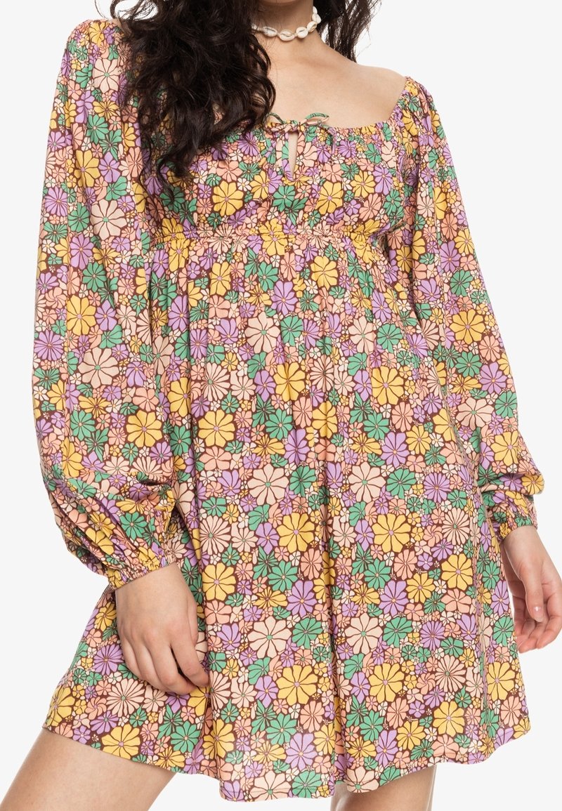 Robe à motifs floraux avec un décolleté carré, des manches longues bouffantes et une taille élastique. Les couleurs incluent le rose, le jaune, le vert et la lavande.