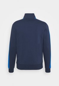 Mörkblå sweatshirt med hög krage, med blå sidostripes. Tillverkad av texturerat tyg, med ribbade ärmslut och nederkant. Visar bakifrån.