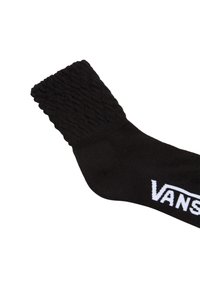 Svart strumpa med en texturerad, ribbad fåll. Har en vävd "VANS"-logotyp i vitt. Materialet verkar mjukt och glansigt.