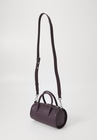 Sac à main en cuir violet, de forme cylindrique avec deux courtes poignées et une longue bandoulière réglable, surface texturée, accents en métal argenté.