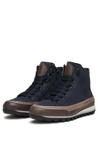 Bottes montantes de marine en tissu et cuir synthétique. Elles disposent d'un laçage sur le devant, d'une fermeture éclair latérale et d'accents marron sur la semelle et le branding.