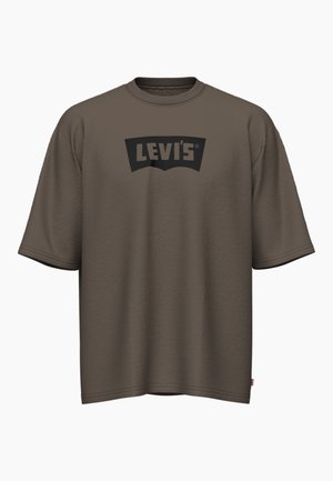 Brun kortermet t-skjorte laget av bomull, med en svart Levi's-logo på en kontrasterende lapp. Løs passform med rund hals.