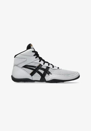 Zapatilla deportiva de caña alta blanca y negra con parte superior de malla, cordones negros y suela negra, mostrada de lado sobre un fondo blanco.