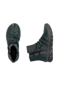 Bottines en cuir vert avec une texture froissée, bout rond, semelle en caoutchouc noir et deux accents de boutons rouges.