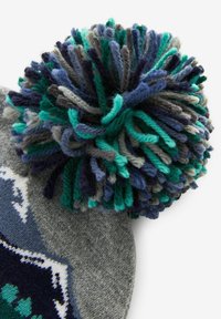 Bonnet en tricot gris en laine avec un grand pompon multicolore présentant des nuances de bleus, de verts et de gris, texture douce et forme arrondie.