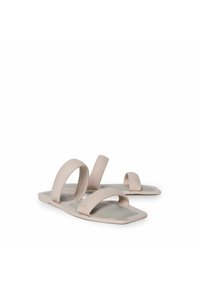 Sandalias deslizantes beige con dos correas anchas y suela plana. Fabricadas con un material suave y flexible. Diseño simple y minimalista con forma rectangular.