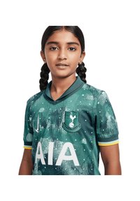 Maglia da calcio verde con un motivo testurizzato, maniche corte, colletto nero e logo "AIA" bianco, con un badge della squadra sul petto.