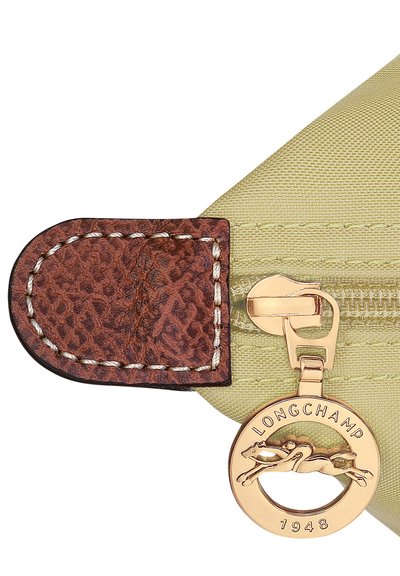 Green fabric zipper pouch with a textured brown leather accent, gold-toned hardware, and a circular logo charm featuring a horse.