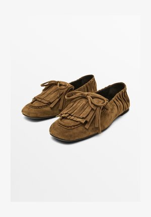 Brązowe zamszowe buty w stylu mokasynów z frędzlami i akcentami w postaci kokardy, o miękkiej fakturze i elastycznej konstrukcji.
