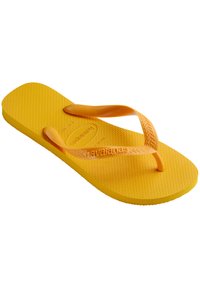 Yellow flip-flop made of rubber with textured footbed and thin straps. Features the brand name 'Havaianas' embossed on the sole and strap.