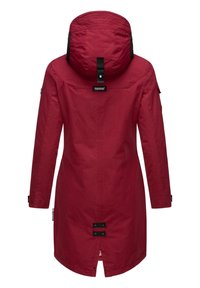 Rode waterdichte parka met een capuchon, voorzien van zwarte accenten, zijzakken en een middenventilatie die wordt vastgezet met twee zwarte knopen. Soepele textuur.