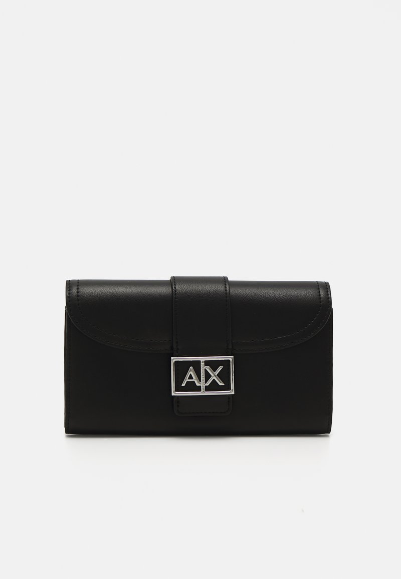 Cartera de cuero negro con tapa redondeada, herrajes plateados con el logo "AX" y una forma rectangular estructurada. Textura suave.