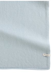 Lichtblauwe gebreide sjaal van zacht materiaal, met een gladde textuur en een label met de tekst "Marc O'Polo" aan één kant.