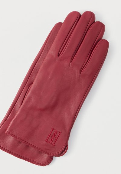 Κόκκινα δερμάτινα γάντια με λεία υφή, διαθέτουν τέσσερα δάχτυλα και ραμμένη άκρη. Περιλαμβάνουν κεντημένο λογότυπο στην περιοχή του καρπού.