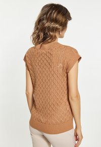 Rudröd stickad tröja med diamantmönster, ribbat halsringning och nederkant. Korta ärmar, texturerad design. Bakvy visad.