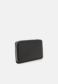 Cartera de cuero negro con superficie texturizada, forma rectangular y cierre de cremallera plateado a lo largo de un lado.